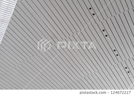 Lights and ventilation system in long line on ceiling of the industrial building. Exhibition Hall. Ceiling factory construction	Lights and ventilation system in long line on ceiling of the industrial 124672227