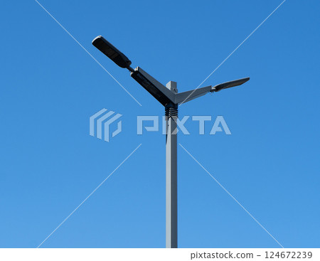 A modern street LED lighting pole. Urban electro-energy technology. Public street lighting pole with LED lights with blue sky background. Poles led. 124672239