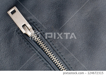 Macro shot of zipper on black leather texture background with stitching. Close-up of black leather material 124672315