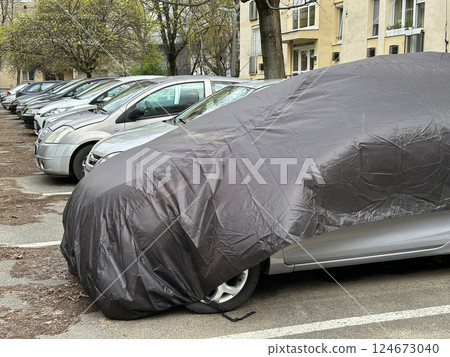 Car under protective cover in the parking lot Car under protective cover in the parking lot 124673040