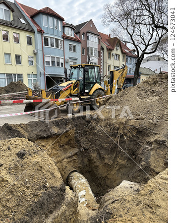 Large hole with pipeline at the road construction site 124673041