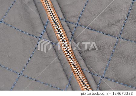 Macro shot of zipper on black leather texture background with stitching. Close-up of black leather material 124673388