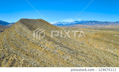 Aerial of Rugged Desert and Snow-Capped Mountains in Nevada 124674111