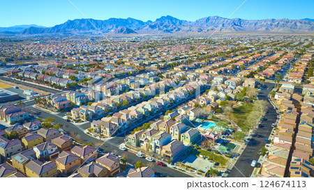 Aerial of Desert Suburban Neighborhood with Mountain Backdrop 124674113