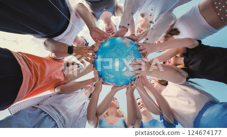 Group of school friends holding a globe, symbolizing environmental awareness, global citizenship, and the importance of protecting planet earth 124674177