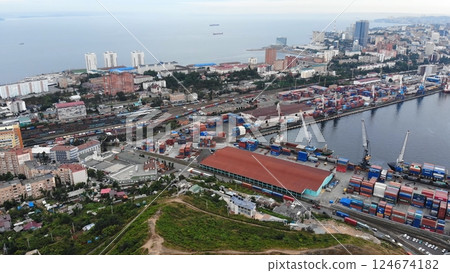 Cargo cranes loading shipping containers at vladivostok seaport, managing maritime trade operations for pacific regional commerce Cargo cranes loading shipping containers at vladivostok seaport, managing maritime trade operations for pacific regional commerce 124674182