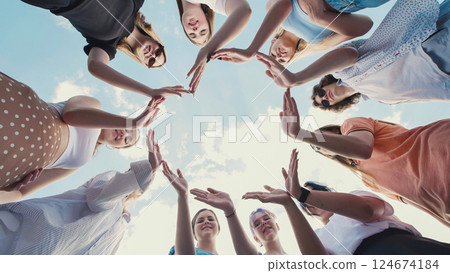 Group of students making a circle with their hands against a blue sky, demonstrating teamwork, friendship, and unity Group of students making a circle with their hands against a blue sky, demonstrating teamwork, friendship, and unity 124674184