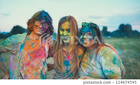 Three happy school buddies, adorned in colorful holi powder, hug and grin, enjoying the festival of colors as a group Three happy school buddies, adorned in colorful holi powder, hug and grin, enjoying the festival of colors as a group 124674545