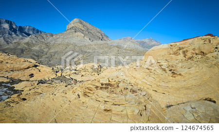 Aerial of Red Rock Formations and Mountains in Nevada Desert 124674565