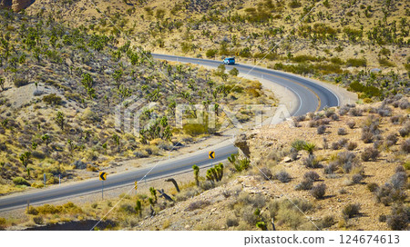 Aerial of Winding Desert Road with Blue Car in Nevada Aerial of Winding Desert Road with Blue Car in Nevada 124674613