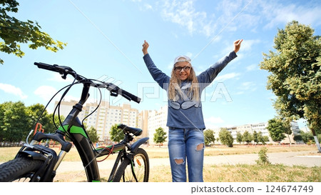 The girl the teenager jumps is happy also to the new bicycle. 124674749