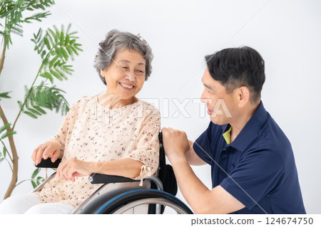 Senior woman in wheelchair and male caregiver Senior woman in wheelchair and male caregiver 124674750