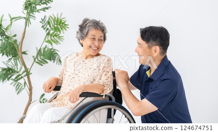 Senior woman in wheelchair and male caregiver Senior woman in wheelchair and male caregiver 124674751