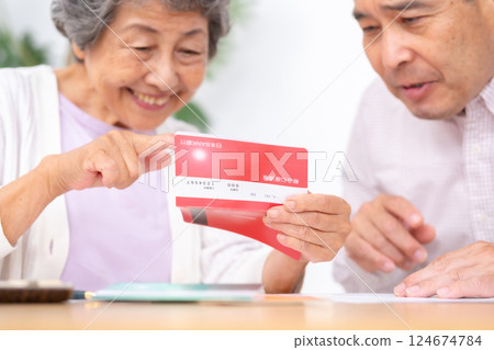 Parent and child looking at bankbook 124674784