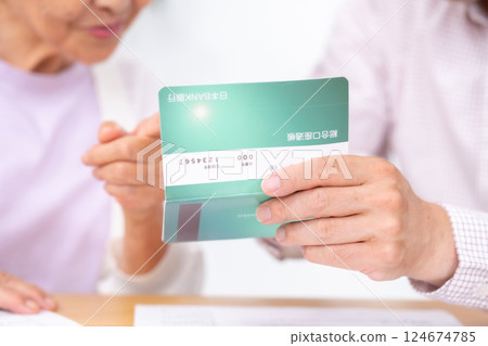 Parent and child looking at bankbook 124674785