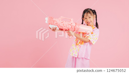 Songkran fun with a happy girl in a floral shirt holding a toy water gun 124675052