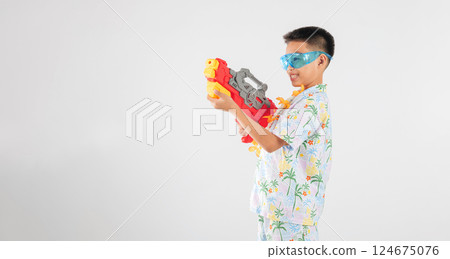 Songkran festival happiness as a smiling child boy plays with a water gun 124675076