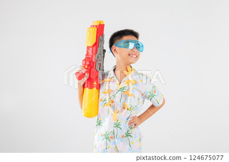 Songkran festival happiness as a smiling child boy plays with a water gun 124675077