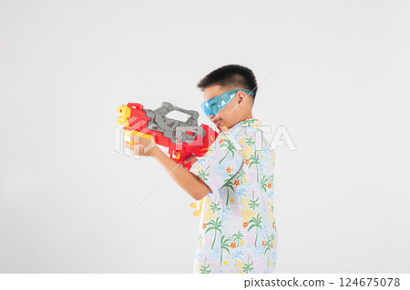 Songkran festival happiness as a smiling child boy plays with a water gun 124675078
