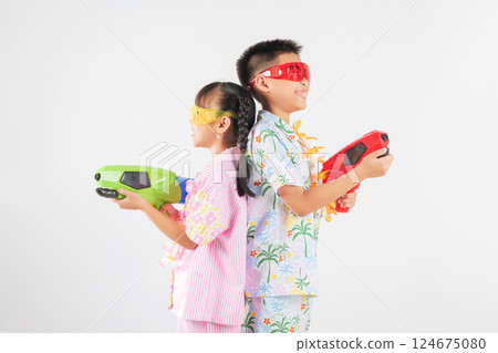 Songkran fun with a cheerful Thai boy and girl enjoying toy water pistols together 124675080