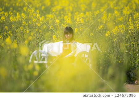 油菜花包圍下微笑的女孩的春天瞬間 油菜花包圍下微笑的女孩的春天瞬間 124675096
