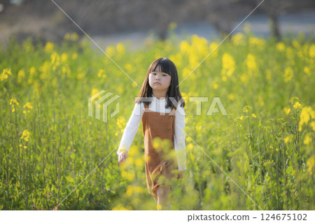 A spring moment with a smiling girl surrounded by rape blossoms 124675102