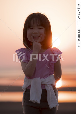 日落時分海灘上微笑的女孩 日落時分海灘上微笑的女孩 124675126