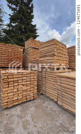 Stacks of wooden planks forming a geometric pattern in a timber warehouse 124675691