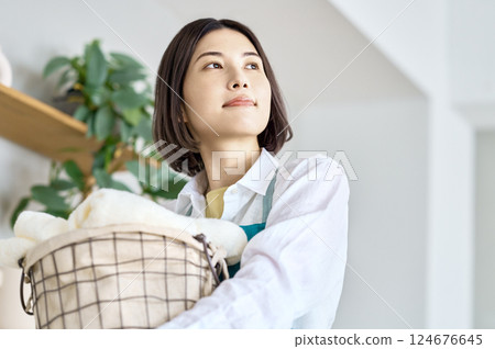 拿著洗衣籃的年輕女子 拿著洗衣籃的年輕女子 124676645
