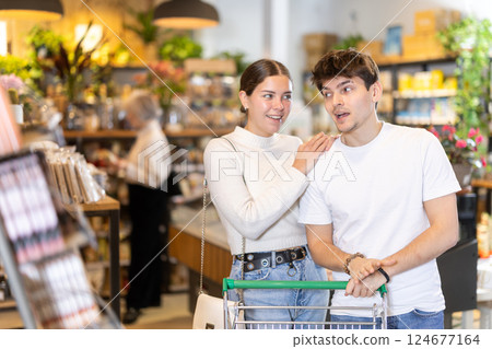 Couple man and woman with shopping cart choosing products Couple man and woman with shopping cart choosing products 124677164