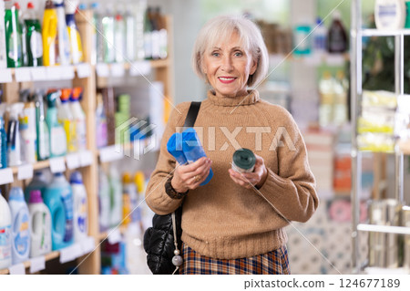 Mature female shopper buying plastic garbage bags in supermarket Mature female shopper buying plastic garbage bags in supermarket 124677189