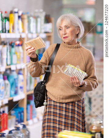Woman choosing a set of clothespins in the store Woman choosing a set of clothespins in the store 124677220