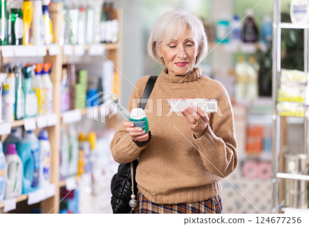 Positive mature woman choosing tooth care products in department store Positive mature woman choosing tooth care products in department store 124677256