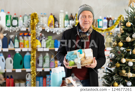 Elderly man choosing a festive shower set in a Christmas supermarket Elderly man choosing a festive shower set in a Christmas supermarket 124677261