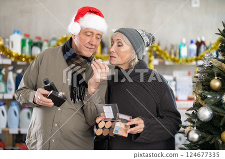 On New Year Eve, senior couple, studies label and choose perfume and eye shadow pallet 124677335