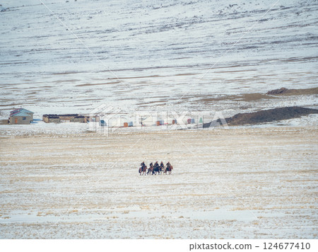 Mongolian horsemen, yurts and snow mountains. Mongolian horsemen, yurts and snow mountains. 124677410
