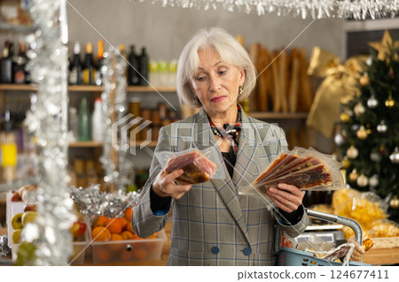 Elderly woman is looking and choose hamon in store. Elderly woman is looking and choose hamon in store. 124677411