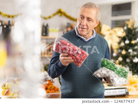 Elderly man chooses candies at grocery store Elderly man chooses candies at grocery store 124677437