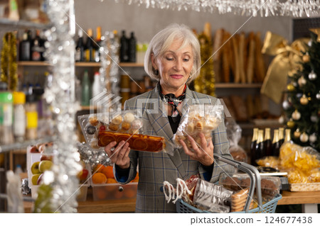 Elderly woman choosing marzipan and panellets in grocery store Elderly woman choosing marzipan and panellets in grocery store 124677438