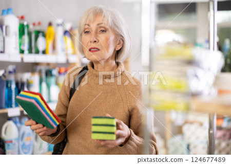 Elderly woman choosing sponges to wash 124677489