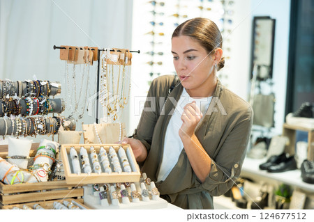 Young woman choosing ring in store 124677512