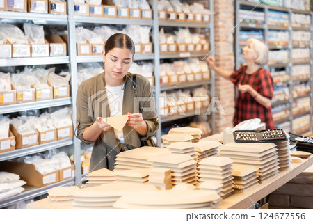 Young woman chooses blanks for making pottery 124677556