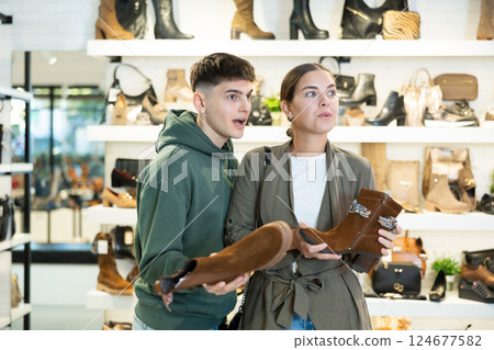 Couple man and woman choosing ankle boots in store Couple man and woman choosing ankle boots in store 124677582