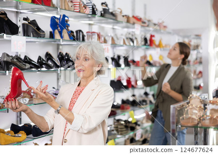 In large shoe store,mature woman is looking at high heel shoes 124677624