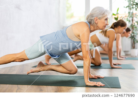Mom, grandma and teenage daughter do Janushirsha Tripadasana cycle of dove pose. 124677690