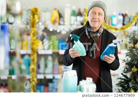 Elderly man choosing cleaning products for the new year 124677909