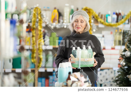 Elderly woman buyer chooses cosmetics gift set for christmas 124677936