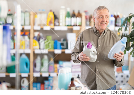 Elderly man choosing cleaning product in supermarket Elderly man choosing cleaning product in supermarket 124678308