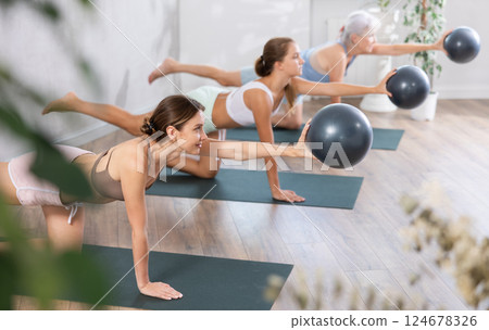 Sporty young woman training with bender ball at gym 124678326