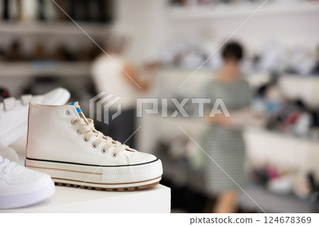 Sneakers displayed on shelf in shoe store Sneakers displayed on shelf in shoe store 124678369
